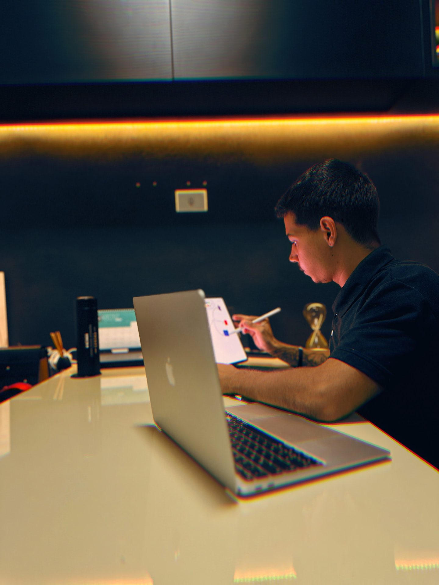 pedrinTEC desenhando o rascunho de uma landing page no tablet ao lado do notebook